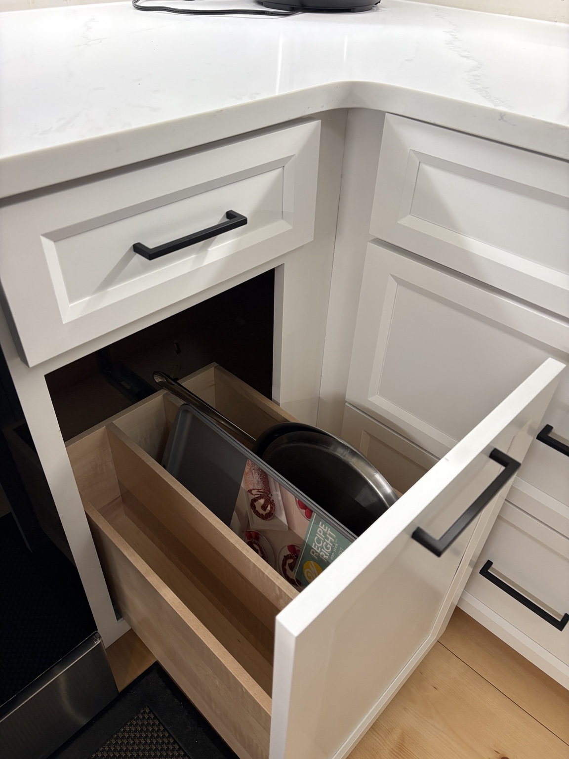 Deep pull-out cabinet drawer organized for cookware and kitchen items