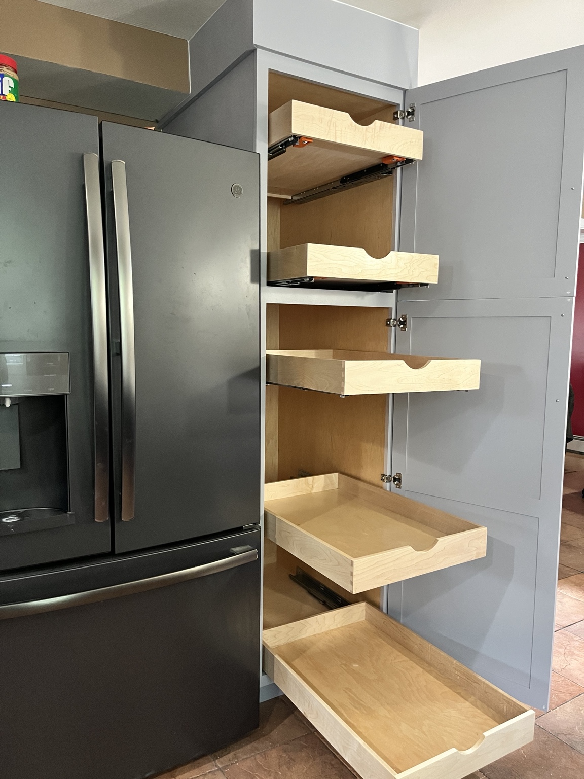 Tall pantry cabinet with multiple maple pull-out drawers