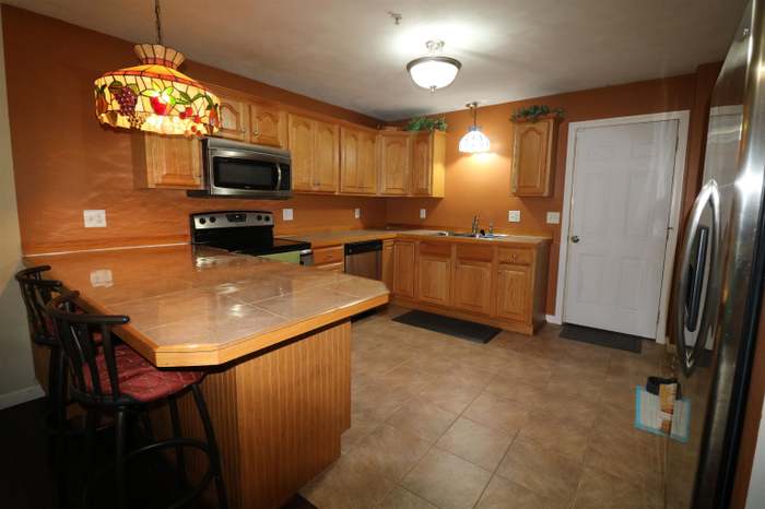 Kitchen before cabinet refacing, with natural wood cabinets